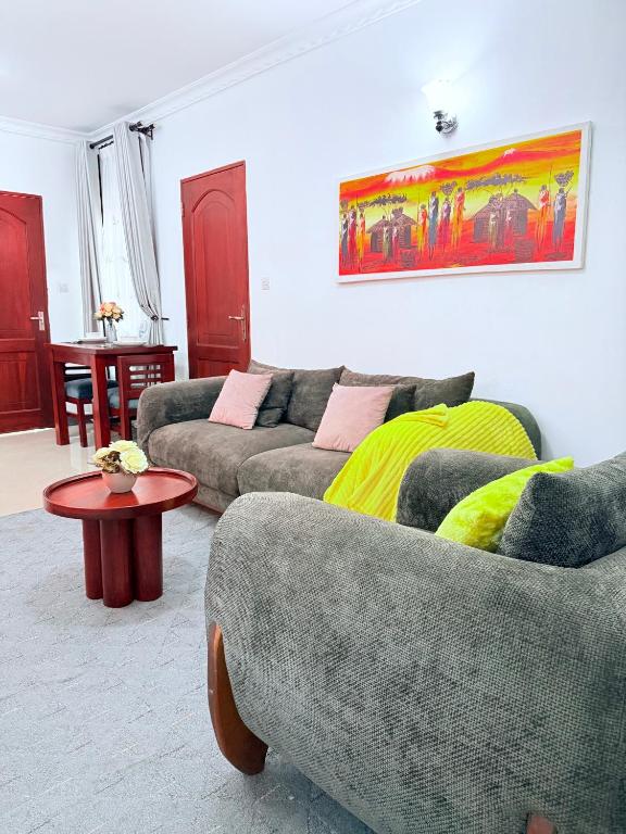 a living room with two couches and a table at Lumora Homes in Arusha