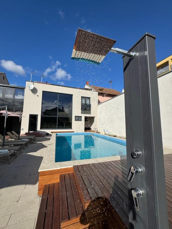 a house with a swimming pool next to a building at 5 Crowns - Osijek - Free EV - Self check in - Pool in Osijek
