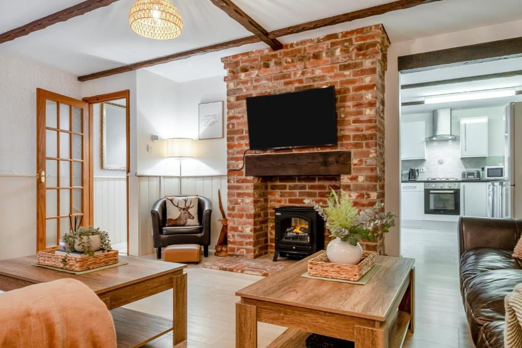 a living room with a brick fireplace with a tv at 3 Bed in Shanklin oc-b36038 in Shanklin