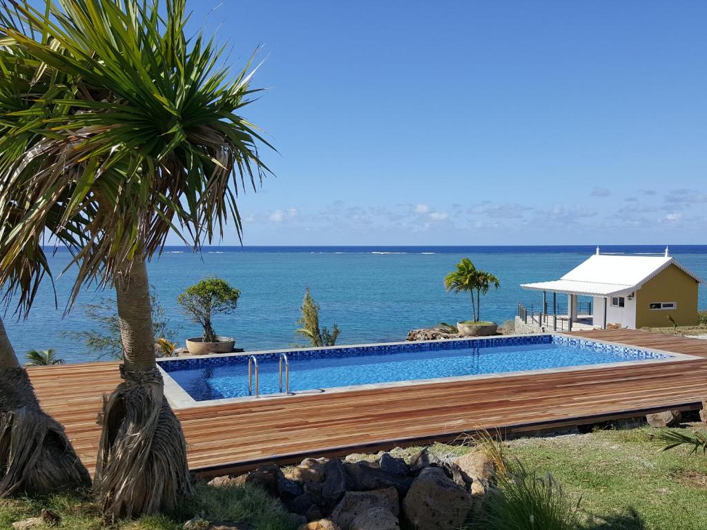 a swimming pool with a view of the ocean at Villas Vetiver in Rodrigues Island
