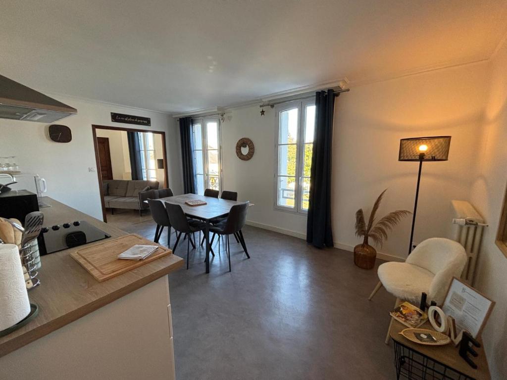 a kitchen and living room with a table and chairs at "Le Cocon Douessin" en hyper centre ! in Doué-la-Fontaine