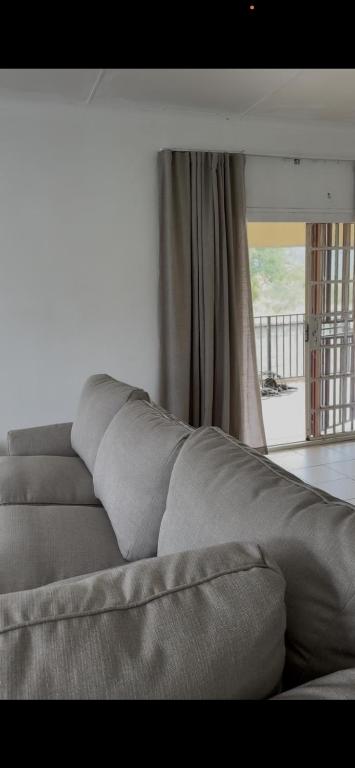 a gray couch in a room with a window at Vellora Haus in Burgersfort