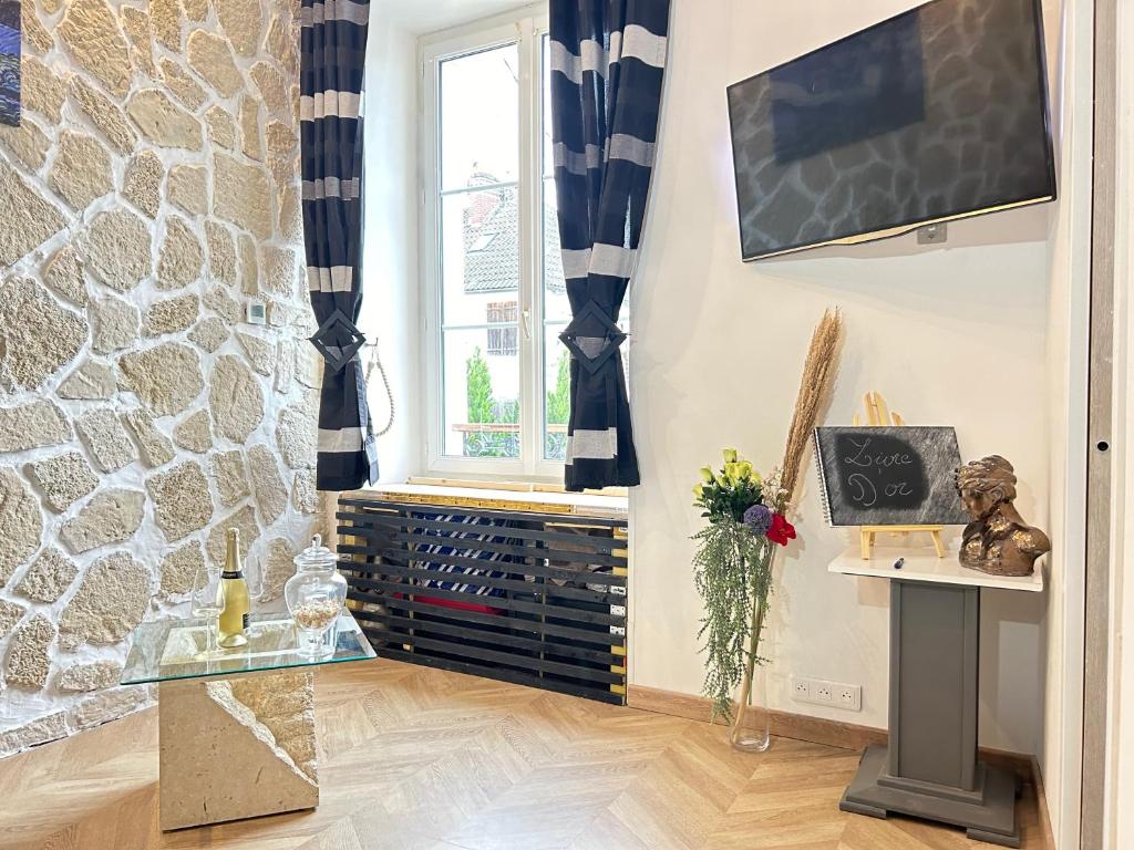 a living room with a glass table and a window at Charmant cocon, Lagny sur marne, parking, wifi, proche Disney RER in Lagny