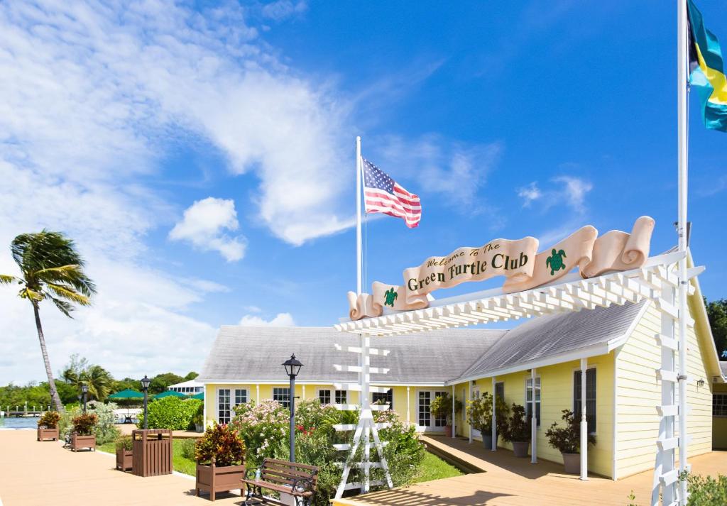 uma vista para a frente do clube de praia com uma bandeira americana em Green Turtle Club Resort & Marina em Green Turtle Cay