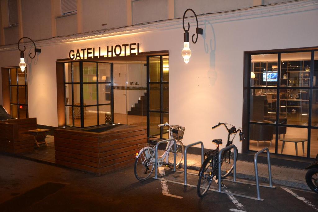 dos bicicletas estacionadas frente a un edificio en Gatell Hotel, en Vilanova i la Geltrú