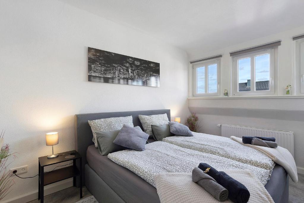 a bedroom with a bed and two windows at Fewo Zeitzauber in Marsberg