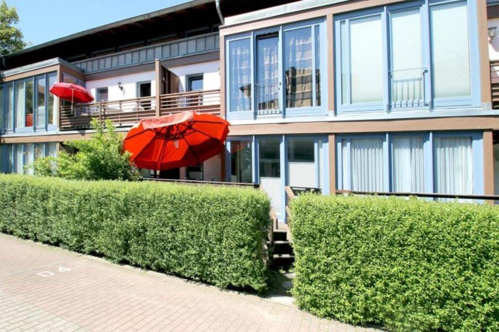 uma casa com um guarda-chuva vermelho em frente em Villa Waldesruh em Kühlungsborn