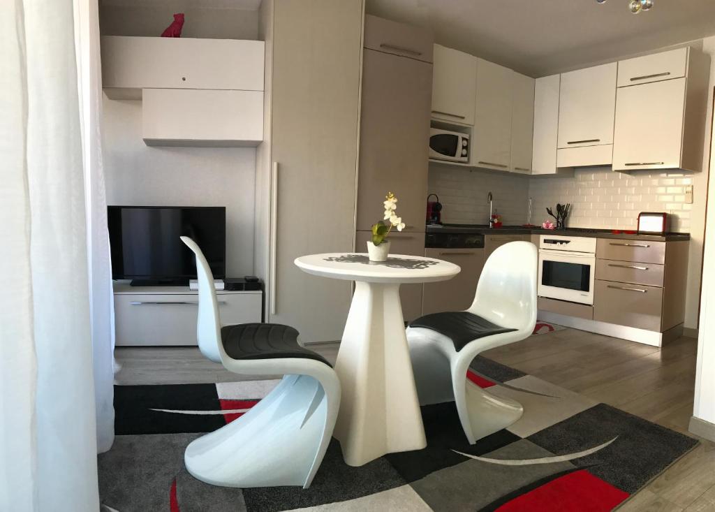 eine Küche mit einem Tisch und Stühlen im Zimmer in der Unterkunft Royal Promenade in Nizza