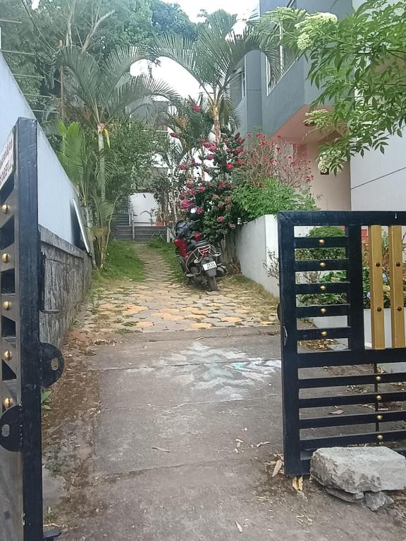 a gate to a house with a motorcycle parked outside at Misty Hills in Yercaud