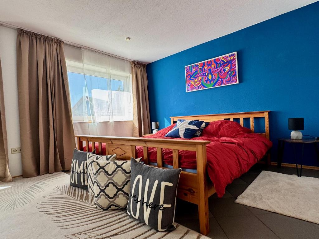 a bedroom with a bed with a blue wall at Gemütliche, sonnendurchflutete Ferienwohnung in Bodenseenähe am Säntisblick in Herdwangen-Schönach