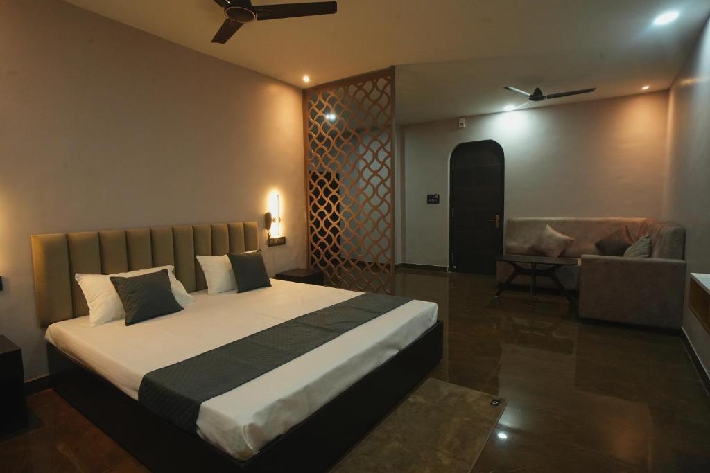 a bedroom with a large bed and a couch at Kasa Courtyard Hotel in Begusarai