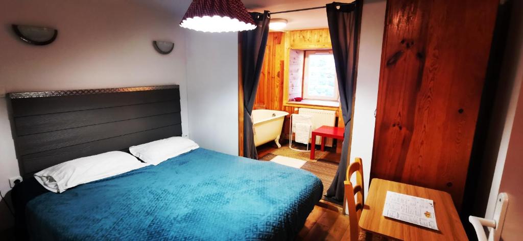 a bedroom with a blue bed and a bathroom at Atelier du pont de Mars in Mars