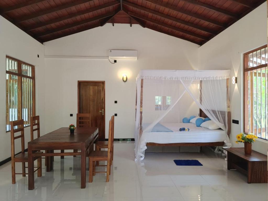 a bedroom with a bed and a table and a dining room at Nature Velora Villa in Tangalle