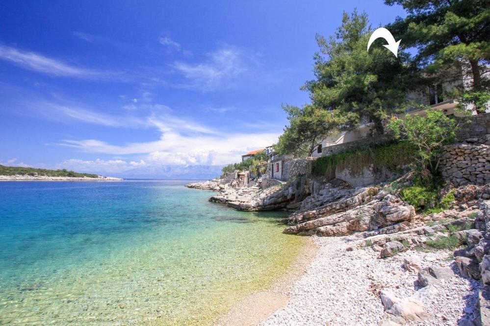 a beach with a rocky shore and the ocean at Robinson Adriatic Queen in Gdinj