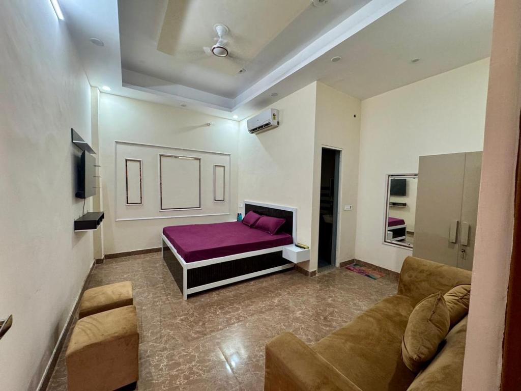 a living room with a couch and a purple bed at Harmony House in Ghaziabad