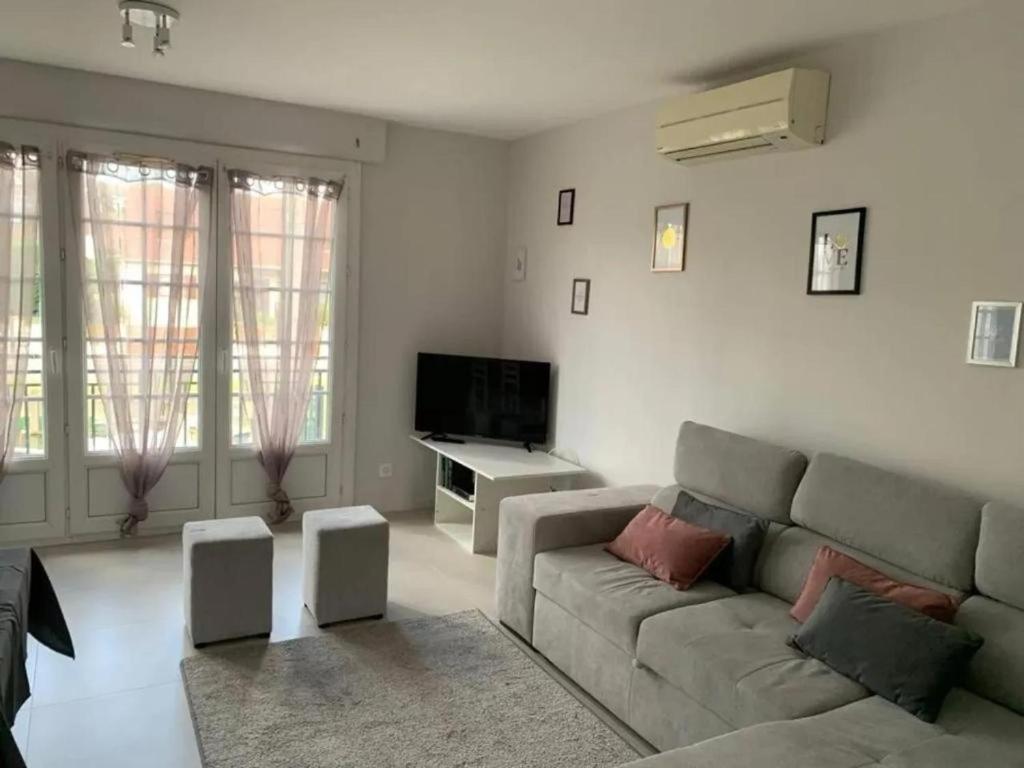 a living room with a couch and a tv at Maison 2 chambre, salon, 5 couchage 57 rue du drain 95480 Pierrelaye in Pierrelaye