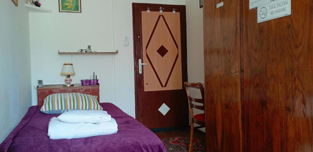 a bedroom with a purple bed and a wooden door at Room for you in Warsaw