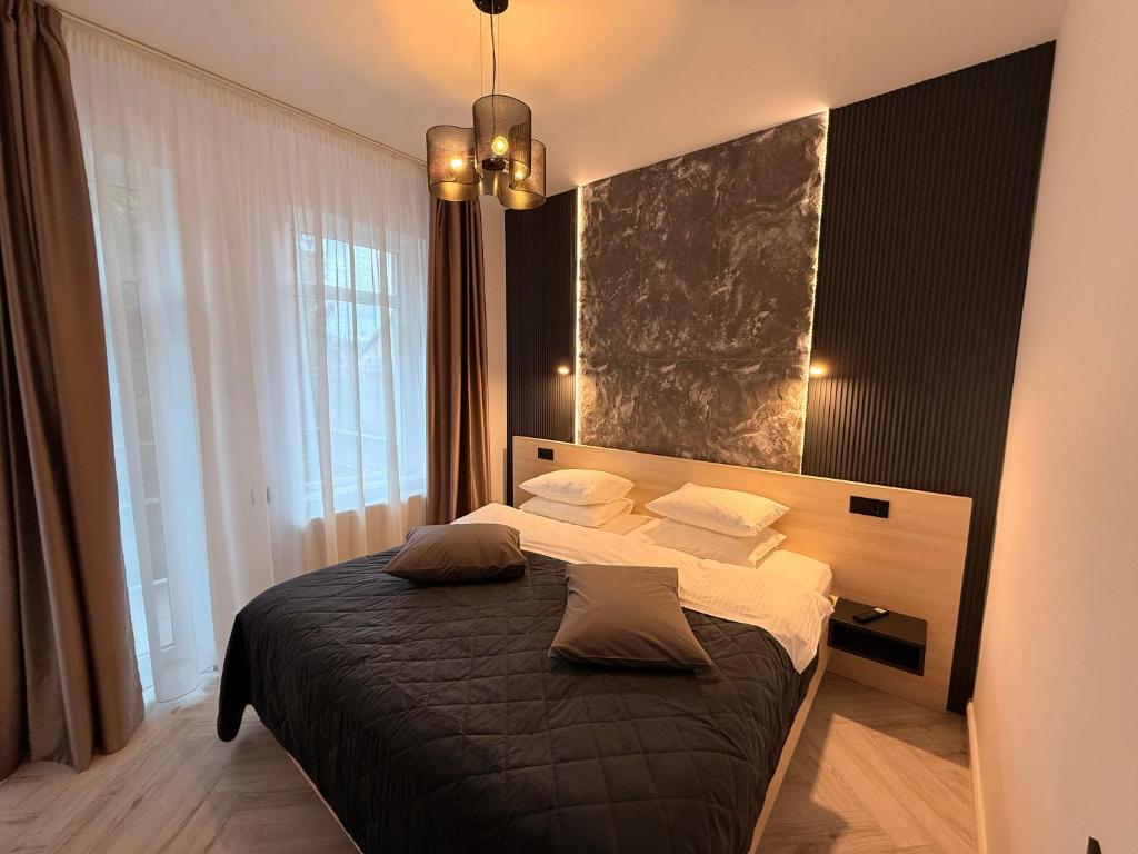 a bedroom with a bed and a large window at Shiro Nord Rooms in Predeal