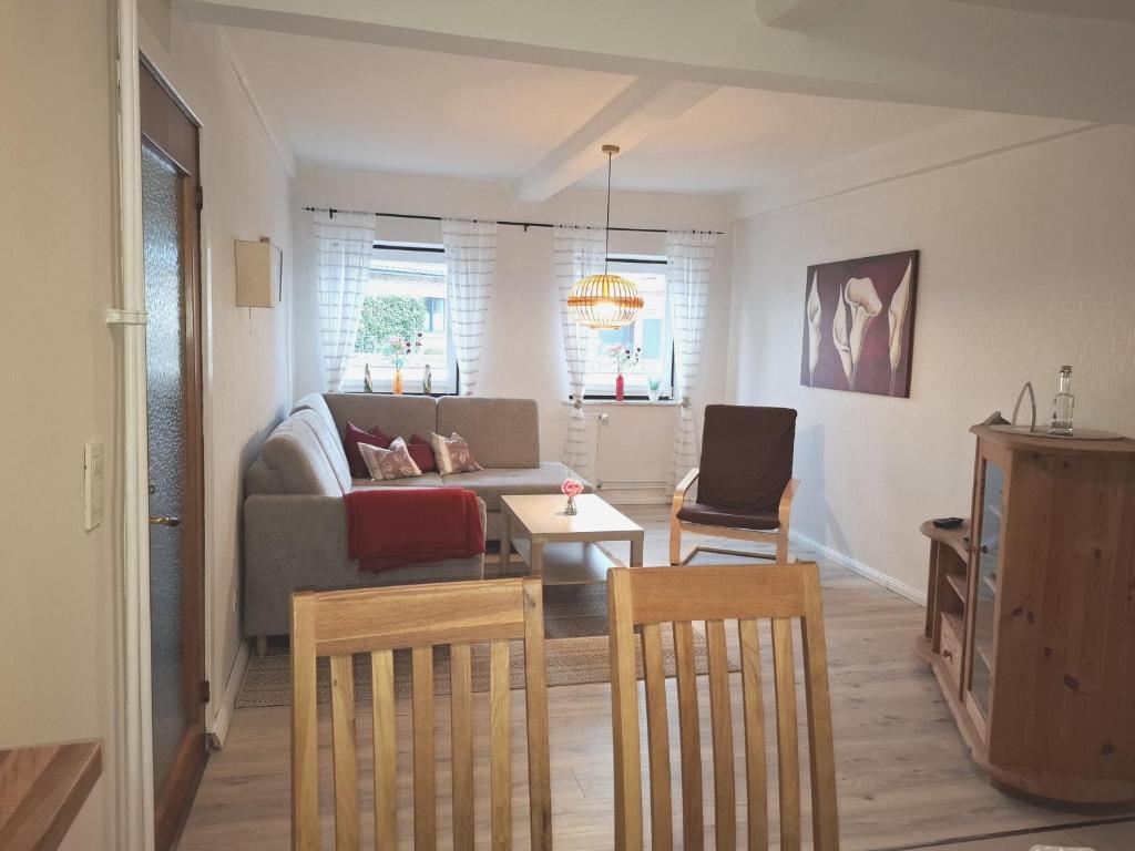 a living room with a couch and a table and chairs at Ferienwohnung Naeve - helle, gemütliche Wohnung auf dem Lande mit zwei Schlafzimmern in Barderup