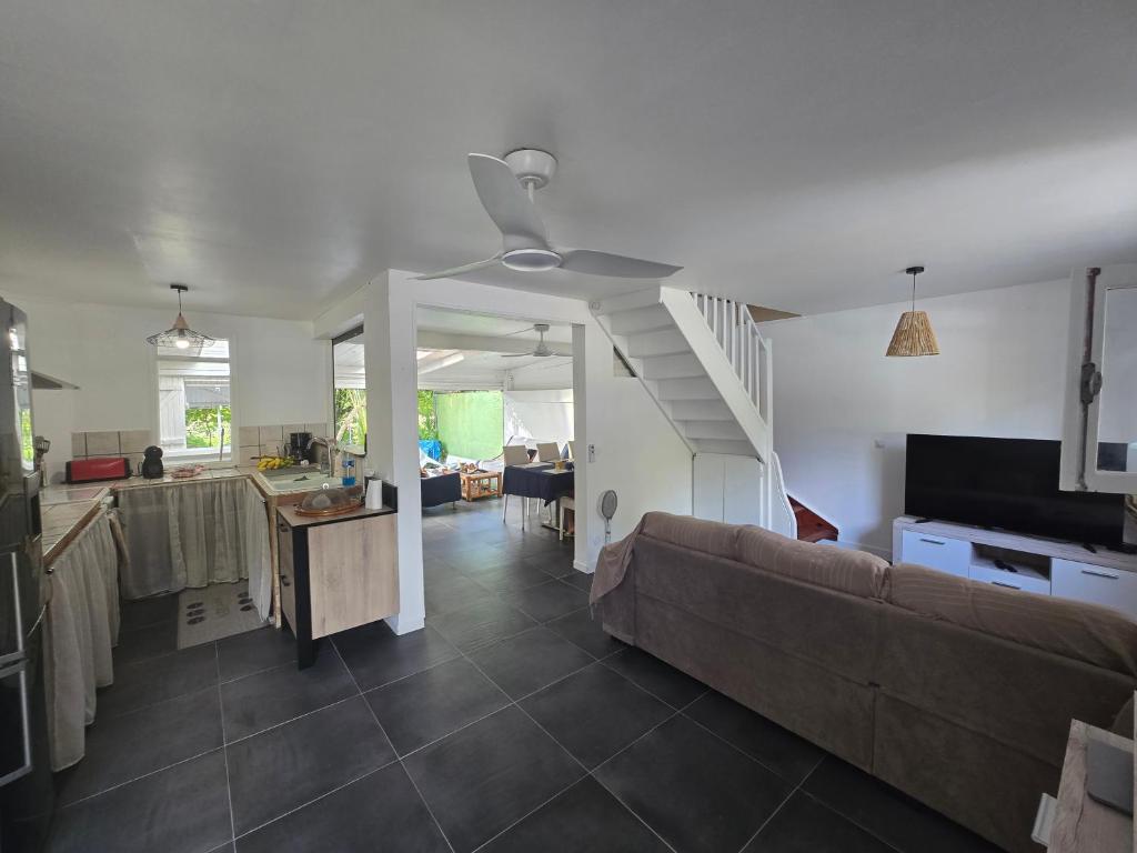 a living room with a couch and a kitchen at Maison Désirée in Sainte-Anne