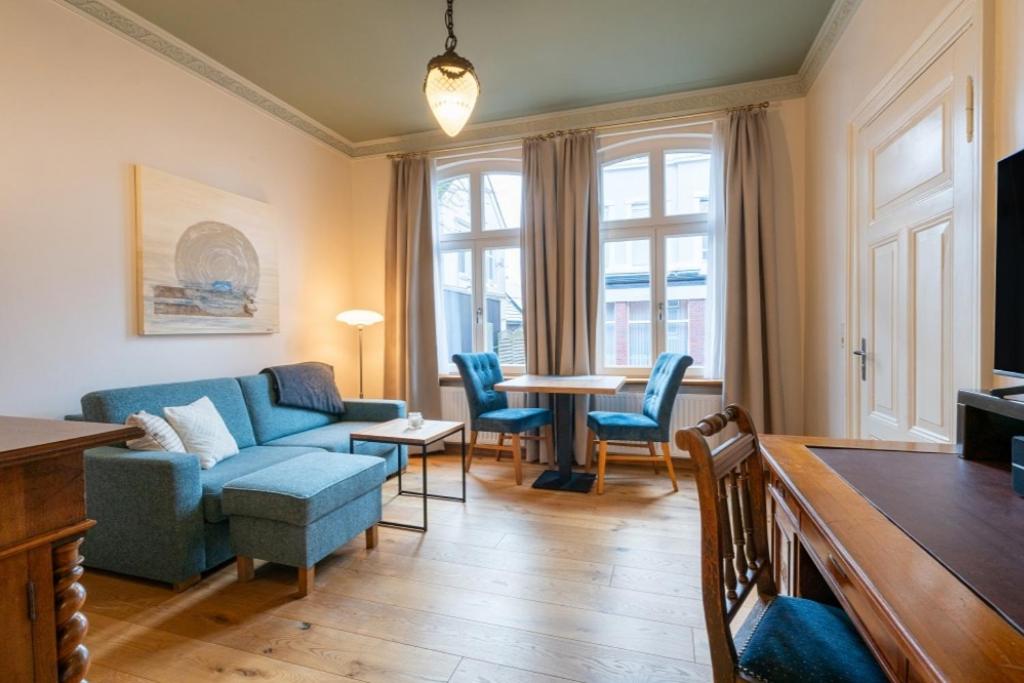 a living room with a couch and chairs and a table at Commandeur-Huus Wohnung 2 in Borkum