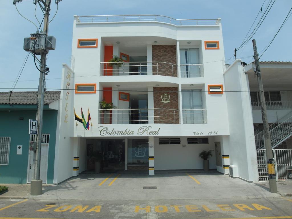 un gran edificio blanco con un cartel. en Colombia Real Hotel, en Barrancabermeja