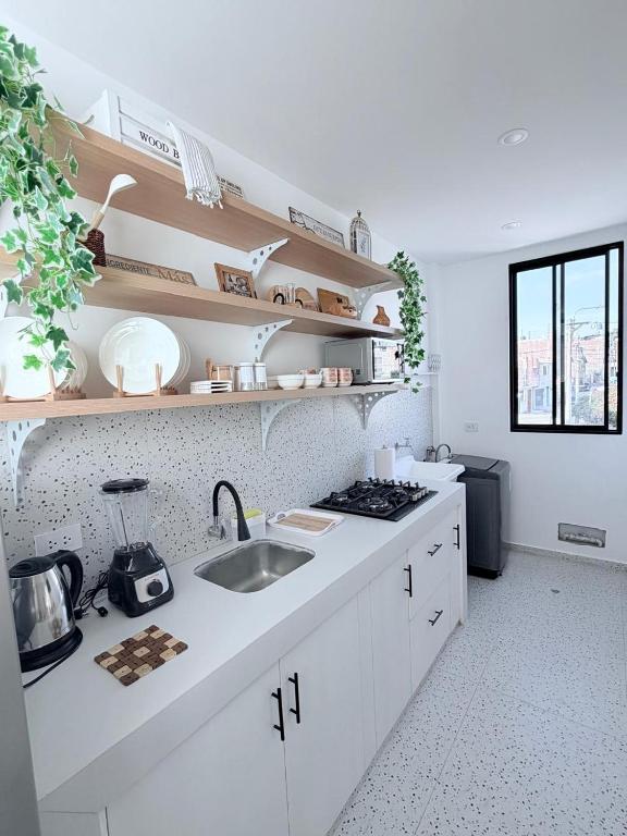 a white kitchen with a sink and a stove at Dpto familiar moderno 2do piso - 2 Hab - 3 camas - wifi - lavadora in Tacna