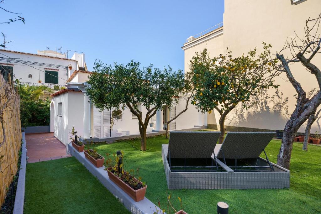 a garden with trees and grass in front of a building at La Perla House in Anacapri