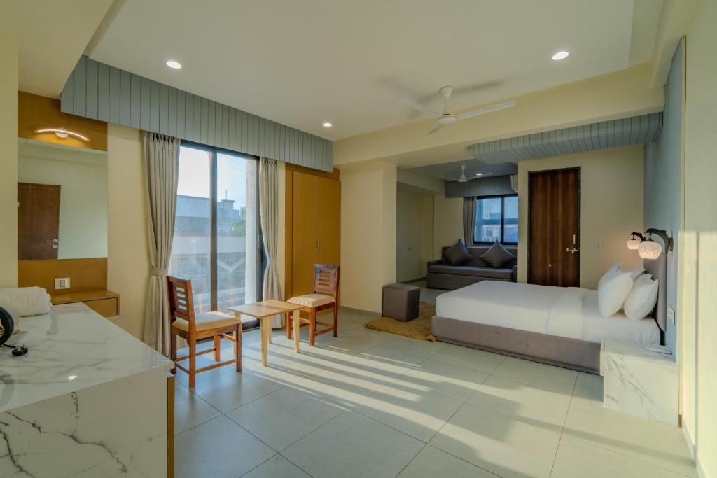 a bedroom with a bed and a living room at hotel mon ville alkapuri in Vadodara