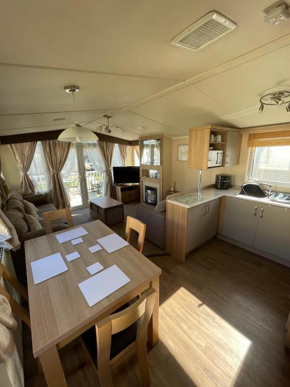 a kitchen and a living room with a table and a kitchen and a living room at Cleethorpes Beach Haven - Broadland Drive in Cleethorpes