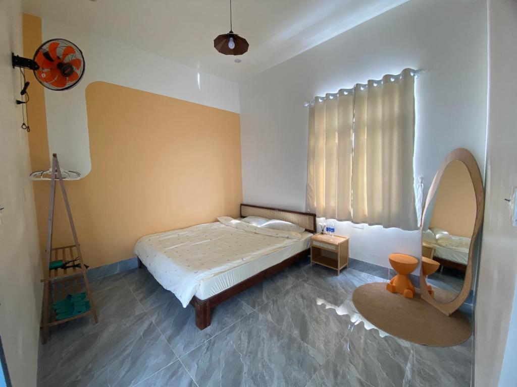 a bedroom with a bed and a mirror in it at Gạo homestay Dốc lết in My Luong