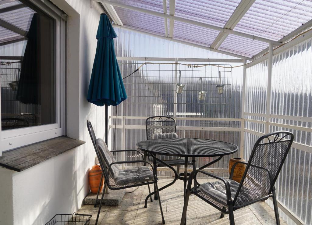 a patio with a table and chairs and an umbrella at Ferienwohnung in der Region Warstein in Warstein