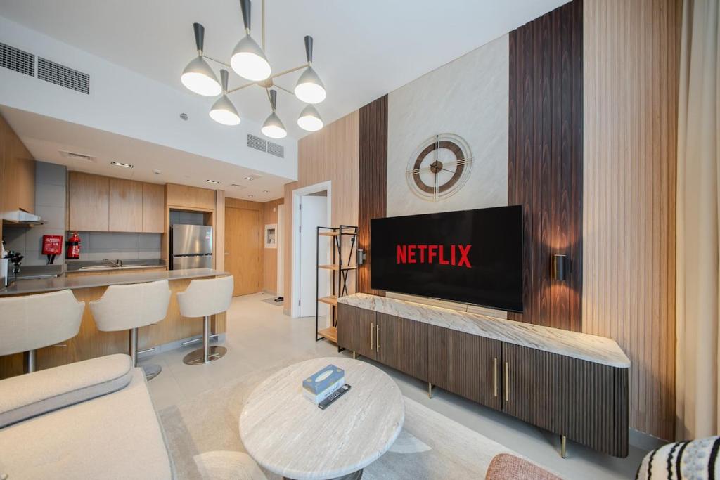 a living room with a television and a kitchen at The Clay Loft Stylish 1BR with Pool Parking CB2-1-RA2-707-1br in Sharjah