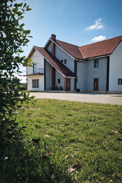 a large white building with a grass yard at Casa Ioanele in Valea Perilor