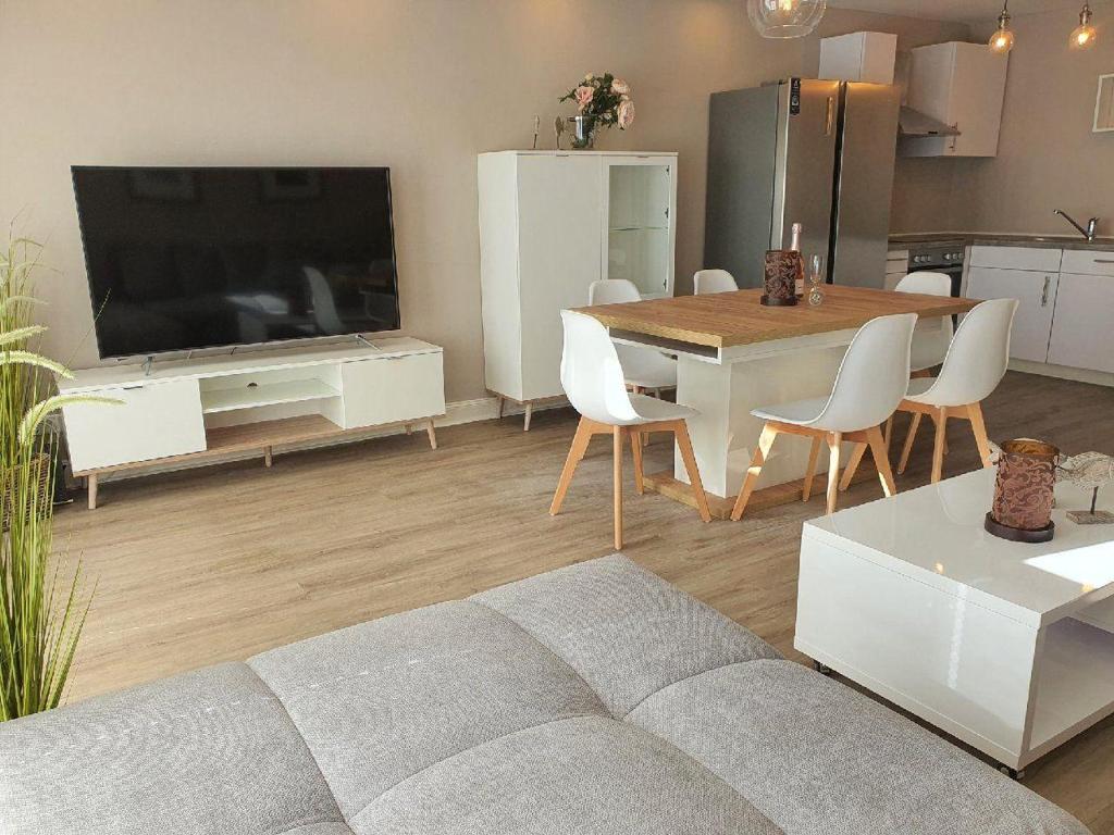 a living room with a couch and a table and a television at Hues-Sylt in Morsum
