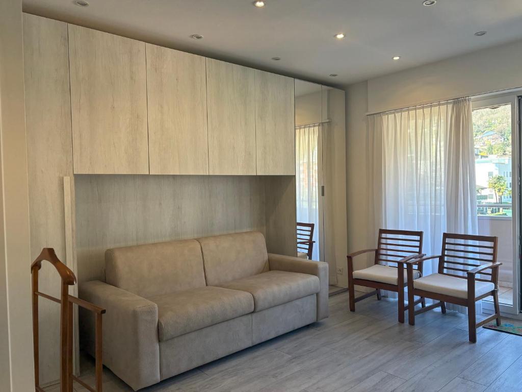 a living room with a couch and two chairs at Lake Agno Apartment in Agno