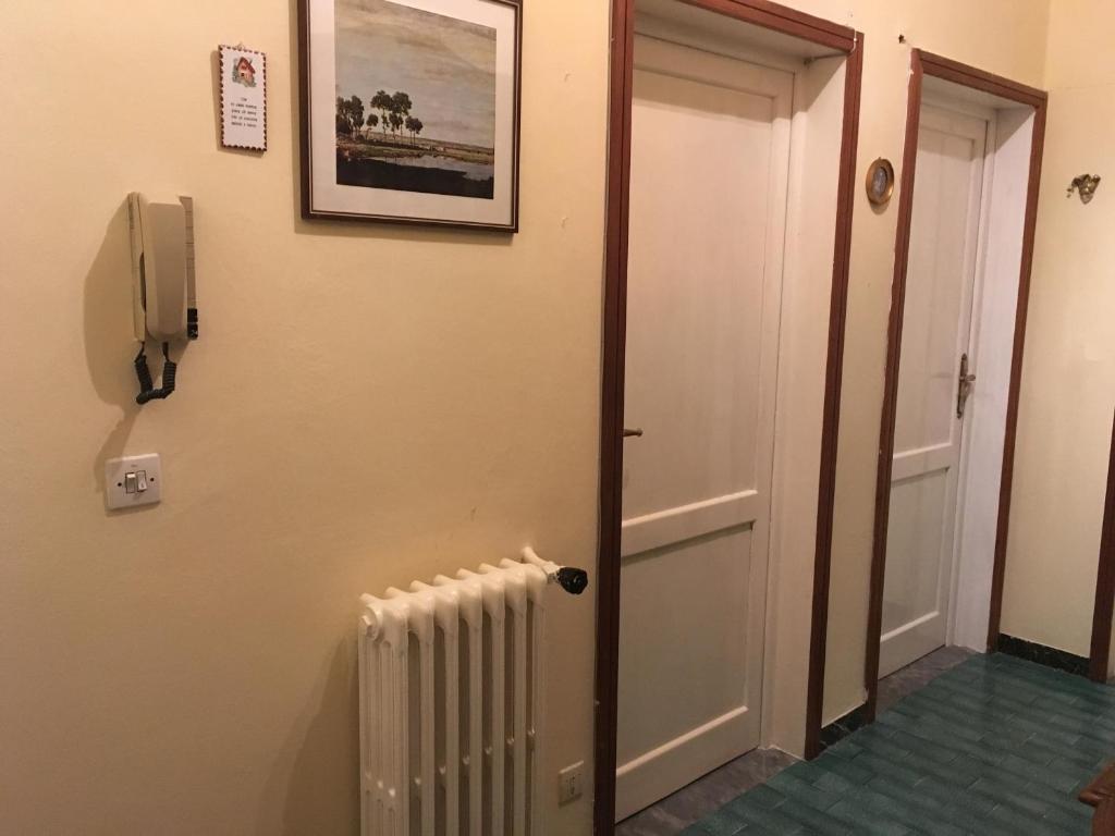 un couloir avec un radiateur et un téléphone sur un mur dans l'établissement House Steccuto, à Florence