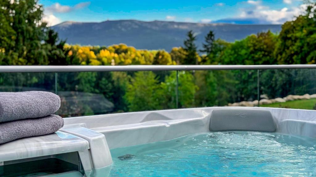 a jacuzzi tub with a view of the mountains at Kras Resort Apartament 110 z prywatnym jacuzzi i widokiem na góry in Szklarska Poręba