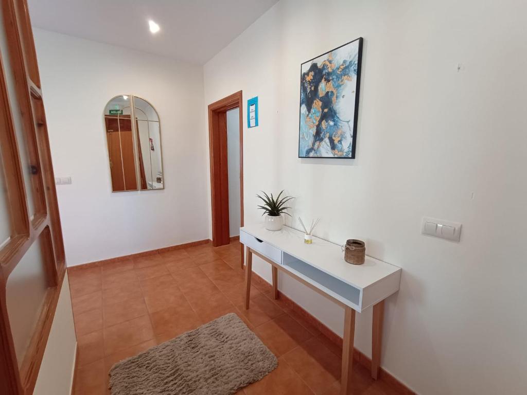 a room with a white desk and a painting on the wall at Pensión Dani in Casinos