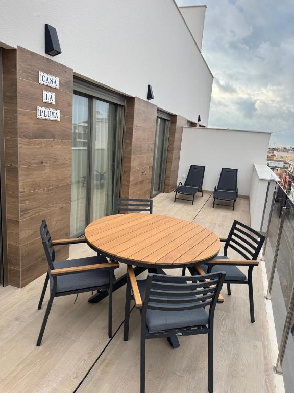a wooden table and chairs on the roof of a building at Casa la Pluma Torrevieja in Torrevieja