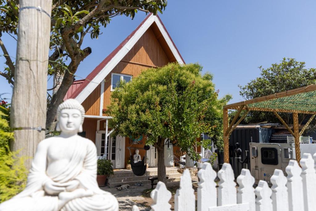a statue in front of a house with a building at Casa Feia Hostel in Costa da Caparica