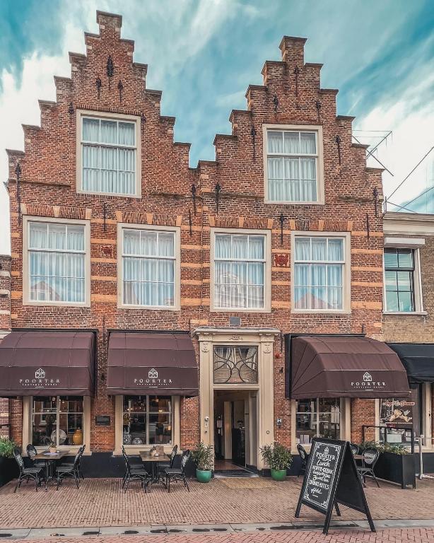 a brick building with tables and chairs in front of it at Poorter Boutique Hotel Brielle in Brielle