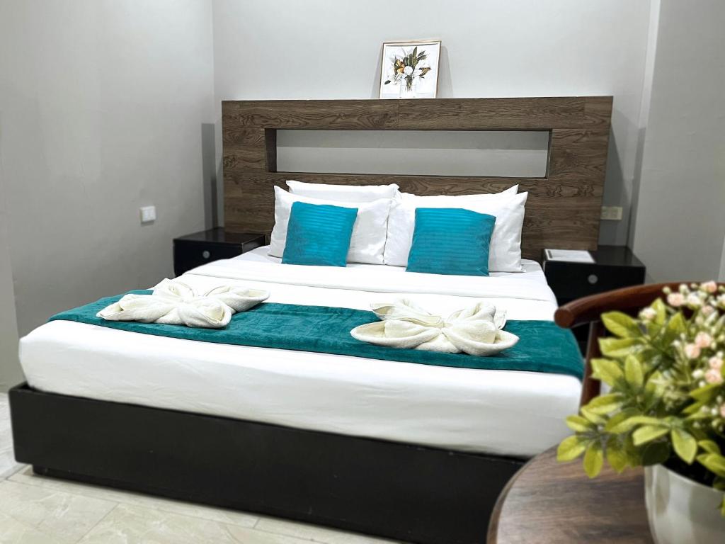 a bedroom with a large bed with blue and white pillows at The JRJF Hotel near Tagum Terminal in Tagum