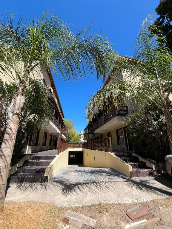 a house with a palm tree in front of it at Departamento duplex Pinamar in Pinamar