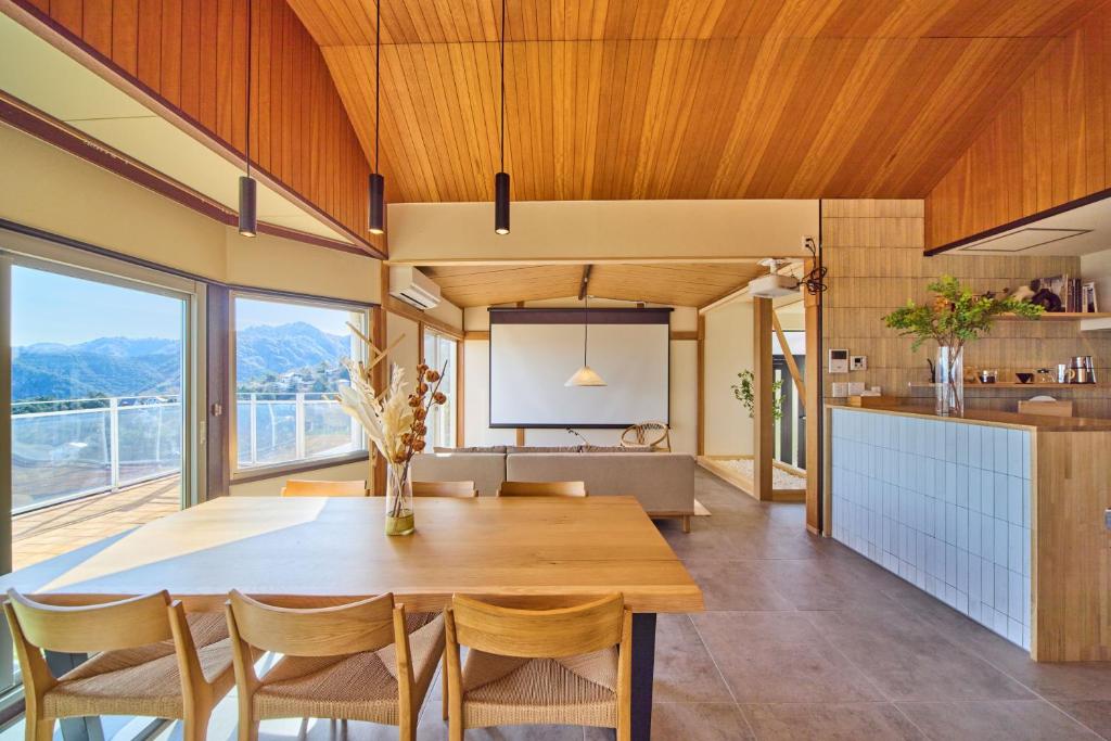 a kitchen and dining room with a wooden table and chairs at プライベートリゾート清風 in Atami