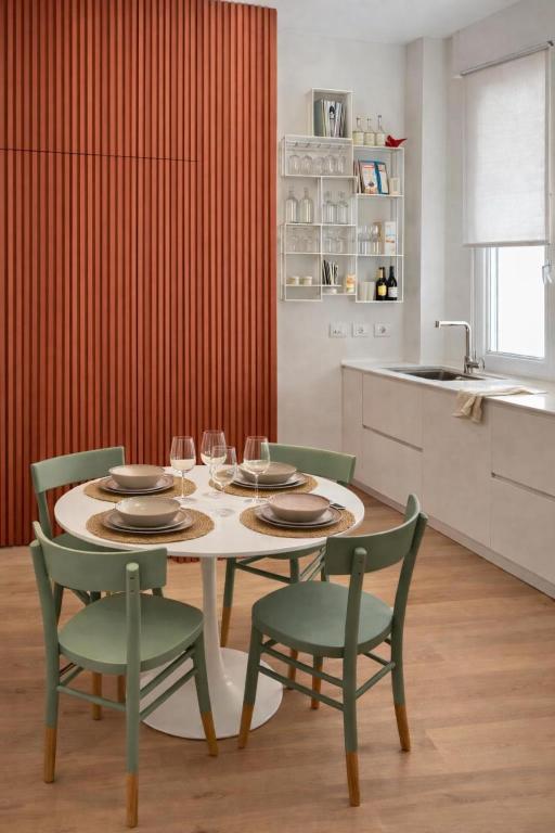 a kitchen with a table and chairs and a kitchen with red curtains at Da Lorenzo Luxury Apartment in Bologna