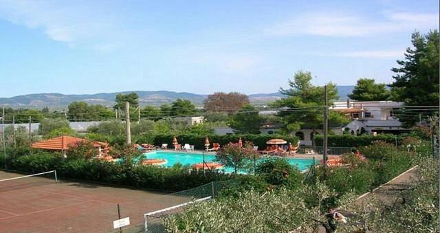 a swimming pool in a yard with a tennis court at Chalet Pineta Mare in Foce Varano