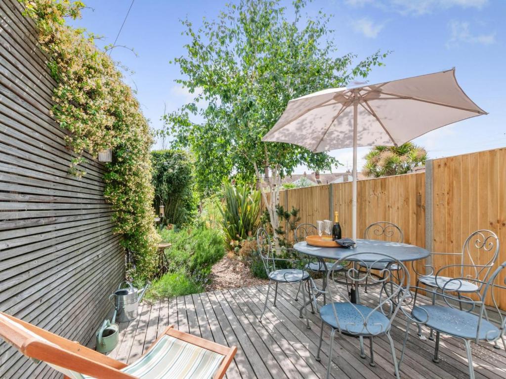 a patio with a table and chairs and an umbrella at 3 Bed in Whitstable oc-wcc17 in Whitstable