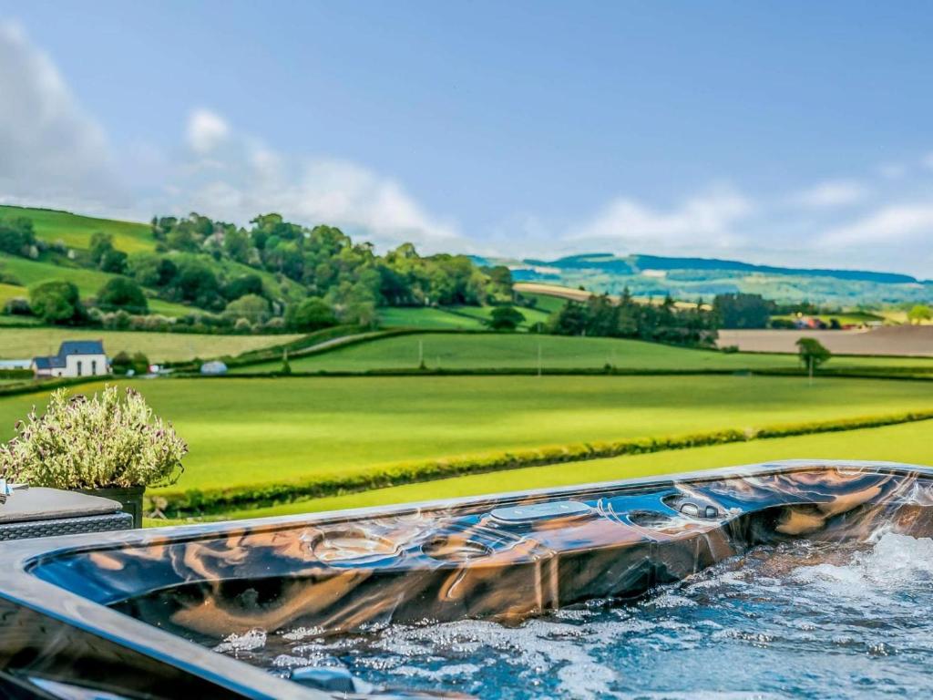 a pool of water with a golf course in the background at 2 Bed in Montgomery oc-83243 in Llandyssil