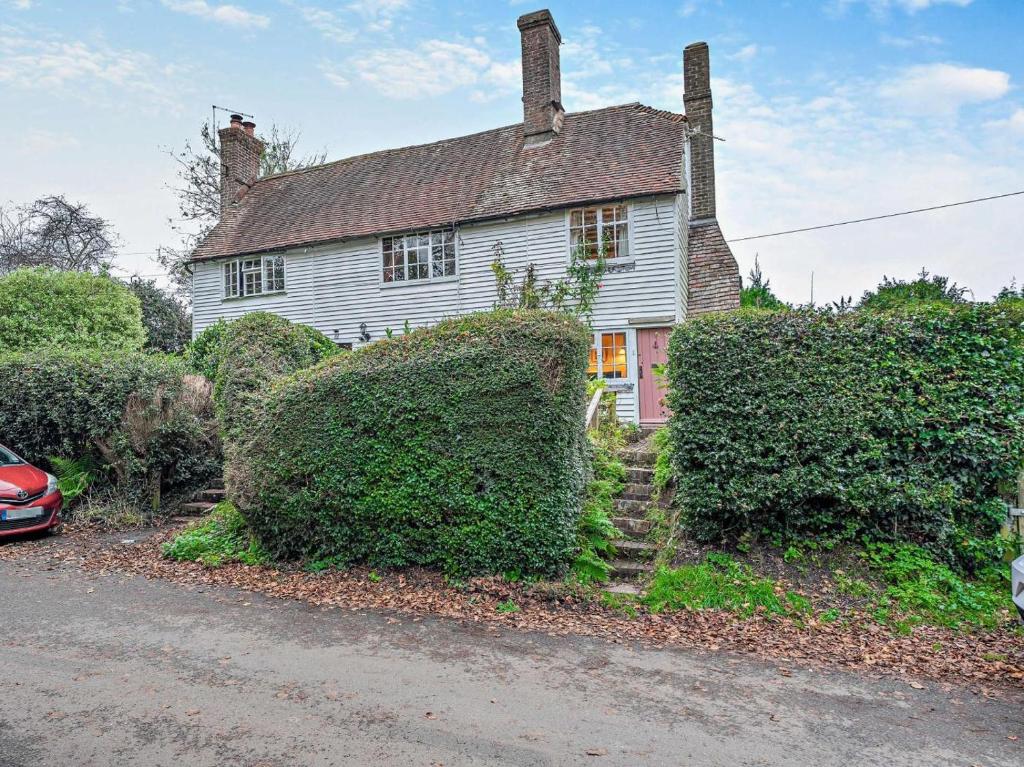 an old white house with bushes in front of it at 1 Bed in Northiam oc-bt033 in Northiam